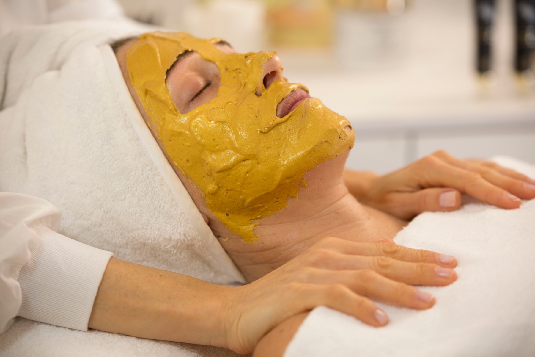 Client relaxing with a restorative facial mask